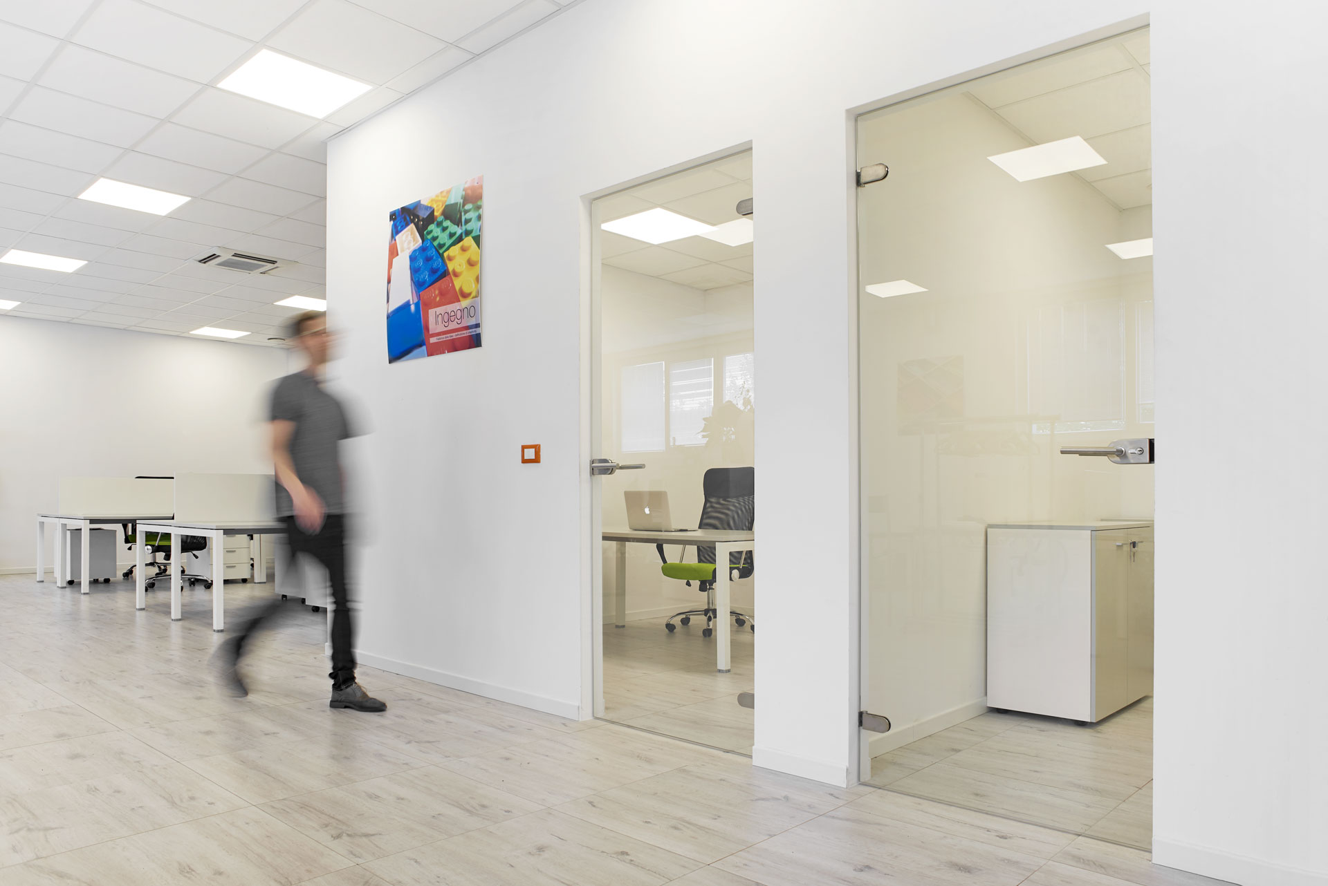Ufficio privato dall'esterno con porte a vetro e persona in movimento